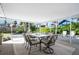 Spacious covered patio featuring a large dining table with seating and views of the meticulously landscaped backyard at 13 Sandcastle Dr, Ormond Beach, FL 32176