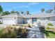 Charming exterior with tidy landscaping, blue door, and attached two-car garage at 13 Sandcastle Dr, Ormond Beach, FL 32176
