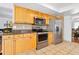 Well-equipped kitchen boasting stainless steel appliances and warm-toned cabinets with granite countertops at 13 Sandcastle Dr, Ormond Beach, FL 32176