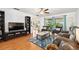 Open-concept living room with hardwood floors, bright windows, stylish furniture, and a view of the covered patio at 13 Sandcastle Dr, Ormond Beach, FL 32176