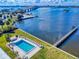 Overhead view of a pool, grassy area, and a dock on the water, set against a backdrop of a bridge at 144 S Halifax Ave # 86, Daytona Beach, FL 32118