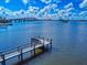 Scenic view of a private dock on the water with a bridge in the background under a partly cloudy sky at 144 S Halifax Ave # 86, Daytona Beach, FL 32118