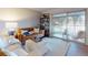 Comfortable living room with a tan leather sofa, plush ottoman, and access to a private screened balcony at 144 S Halifax Ave # 86, Daytona Beach, FL 32118