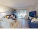 Bright living room showcasing a cozy couch, accent pillows, and a sliding glass door to the outdoor balcony at 144 S Halifax Ave # 86, Daytona Beach, FL 32118