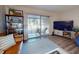 Bright living room with a leather couch, lots of books, and a sliding glass door to the screened balcony at 144 S Halifax Ave # 86, Daytona Beach, FL 32118