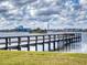 A long wooden pier extending into lake with an inviting view to the cityscape in the distance at 144 S Halifax Ave # 86, Daytona Beach, FL 32118