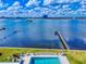 Aerial view of a community pool next to a grassy area and a private dock over a body of water at 144 S Halifax Ave # 86, Daytona Beach, FL 32118