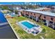 Aerial view of a well-maintained community pool overlooking the intercoastal waterway with lounge chairs and a grilling area at 144 S Halifax Ave # 86, Daytona Beach, FL 32118