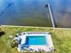 Aerial image of a community pool and dock featuring lounge seating and picturesque waterfront at 144 S Halifax Ave # 86, Daytona Beach, FL 32118