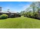 Beautiful backyard featuring lush green grass, a screened porch and mature landscaping at 160 Limewood Pl # 1, Ormond Beach, FL 32174