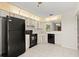Well-lit kitchen featuring black appliances, tile flooring, and ample cabinet space at 160 Limewood Pl # 1, Ormond Beach, FL 32174