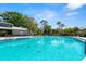 Community pool with turquoise water, palm trees and lounge seating at 160 Limewood Pl # 1, Ormond Beach, FL 32174