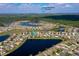 Community aerial view with ponds and Daytona International Speedway; subject property indicated by a blue arrow at 1750 Savannah Ln, Port Orange, FL 32128