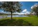 Serene backyard view featuring a lush lawn and a tranquil pond at 1750 Savannah Ln, Port Orange, FL 32128