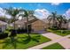 Inviting single-Gathering home with mature palm trees, green lawn, and partial lake view at 1750 Savannah Ln, Port Orange, FL 32128