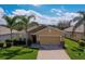 Charming single-story home featuring a two-car garage and well-maintained landscaping with palm trees at 1750 Savannah Ln, Port Orange, FL 32128