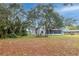 Expansive backyard featuring large trees, lawn and a screened porch providing an inviting outdoor space at 1983 Stacey Cir, Deltona, FL 32738