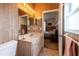 Traditional bathroom with wood paneling, marble vanity, and an open doorway to the adjacent bedroom at 1983 Stacey Cir, Deltona, FL 32738