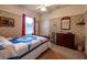 This cozy bedroom has traditional furnishings, floral wallpaper, and a window with red curtains at 1983 Stacey Cir, Deltona, FL 32738