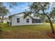 Exterior view featuring a screened porch and a well-maintained lawn area around the perimeter of the home at 1983 Stacey Cir, Deltona, FL 32738