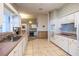 Spacious kitchen featuring white cabinets, stainless steel sink, and tile flooring at 1983 Stacey Cir, Deltona, FL 32738