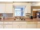 This vintage kitchen features white cabinets, stainless steel sink, and a window overlooking the outdoors at 1983 Stacey Cir, Deltona, FL 32738