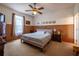 Comfortable bedroom with a ceiling fan, patterned wallpaper, and a large window providing plenty of light at 1983 Stacey Cir, Deltona, FL 32738