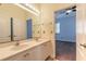 Well-lit bathroom with double vanity, white cabinets, and a doorway leading to the bedroom at 20 Promenade At Lionspaw, Daytona Beach, FL 32124