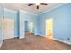 Bedroom with blue walls, carpet, and closet with mirrored doors at 20 Promenade At Lionspaw, Daytona Beach, FL 32124