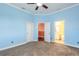 Bedroom with blue walls, doors to hallway and bathroom, carpet, crown molding, and ceiling fan at 20 Promenade At Lionspaw, Daytona Beach, FL 32124