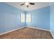 Cozy bedroom with blue walls, carpet, crown molding, a ceiling fan, and two windows with shutters at 20 Promenade At Lionspaw, Daytona Beach, FL 32124