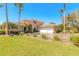 Stunning, yellow, two-story home with a three-car garage and lush tropical landscaping at 20 Promenade At Lionspaw, Daytona Beach, FL 32124