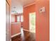 Hallway showcasing hardwood floors leading to bedroom with large windows and attached bathroom featuring modern fixtures at 20 Promenade At Lionspaw, Daytona Beach, FL 32124
