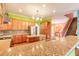 Spacious eat-in kitchen featuring granite countertops and wood cabinets with views of the staircase at 20 Promenade At Lionspaw, Daytona Beach, FL 32124