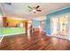 Open-concept living room with wood floors and views of the kitchen and lanai at 20 Promenade At Lionspaw, Daytona Beach, FL 32124
