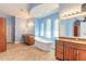 Bright main bathroom featuring a soaking tub, dual vanities, and arched windows at 20 Promenade At Lionspaw, Daytona Beach, FL 32124