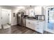 Bright kitchen features stainless steel appliances, white cabinets, gray countertops, and hardwood floors at 2057 Hillview Circle, Deltona, FL 32738