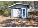 Blue storage shed featuring roll-up door and standard door at 2057 Hillview Circle, Deltona, FL 32738