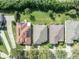 Aerial view of the roofs of multiple houses, some with solar panels, amidst lush green trees at 212 Stonington Way, Deland, FL 32724