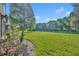 Lush green backyard with flowerbeds, mature landscaping, and ample space for outdoor enjoyment at 212 Stonington Way, Deland, FL 32724