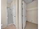 En suite bathroom featuring a walk-in shower and neutral tile, with a peek into the large walk-in closet at 212 Stonington Way, Deland, FL 32724