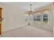 Bright dining room with patterned carpet, chandelier, and three large windows bringing in lots of natural light at 212 Stonington Way, Deland, FL 32724