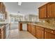 Well-equipped kitchen with granite countertops, tile flooring and wood cabinets leading to the dining area at 212 Stonington Way, Deland, FL 32724