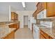 Kitchen features granite countertops, white appliances, tile flooring and wood cabinets for ample storage at 212 Stonington Way, Deland, FL 32724