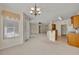 Open-concept living room with chandelier, neutral walls, and opening to kitchen with breakfast bar at 212 Stonington Way, Deland, FL 32724