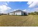 Back exterior view of a single-story home with a spacious backyard at 2236 Oconnel Dr, Ormond Beach, FL 32174