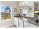 Bright bathroom with a large mirror, long countertop, and a window offering serene outdoor views at 2236 Oconnel Dr, Ormond Beach, FL 32174