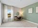 Well-lit bedroom with view of outdoors is setup as an office with desk and decor at 2236 Oconnel Dr, Ormond Beach, FL 32174