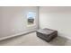 Bedroom with neutral walls, carpeted floors, a window and a leather ottoman adding charm to the space at 2236 Oconnel Dr, Ormond Beach, FL 32174