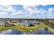 Beautiful view of the house surrounded by lush greenery, a pond, and a clear sky with fluffy white clouds at 2236 Oconnel Dr, Ormond Beach, FL 32174